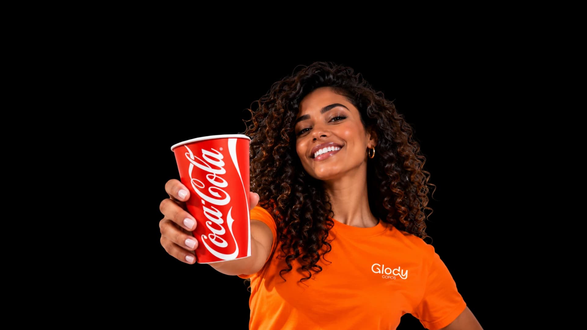 Mulher sorrindo com camiseta Glody, estendendo um copo